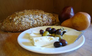 still life with 5-grain loaf, cheese & olives